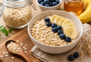 Tigela com aveia, banana e mirtilos representando uma alimentação rica em fibras para a saúde do intestino.